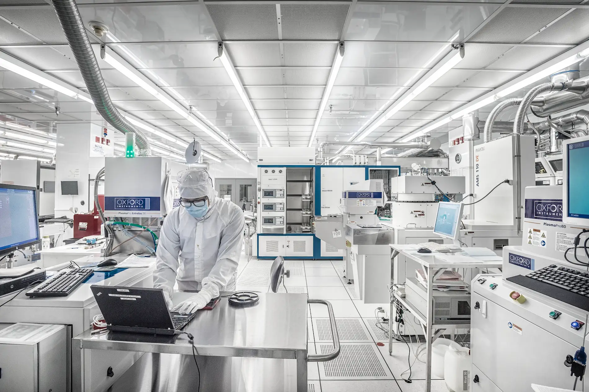 Researcher operating advanced nanofabrication equipment at the University of Alberta nanoFAB, inside a high-tech cleanroom environment for semiconductor and microfabrication research.