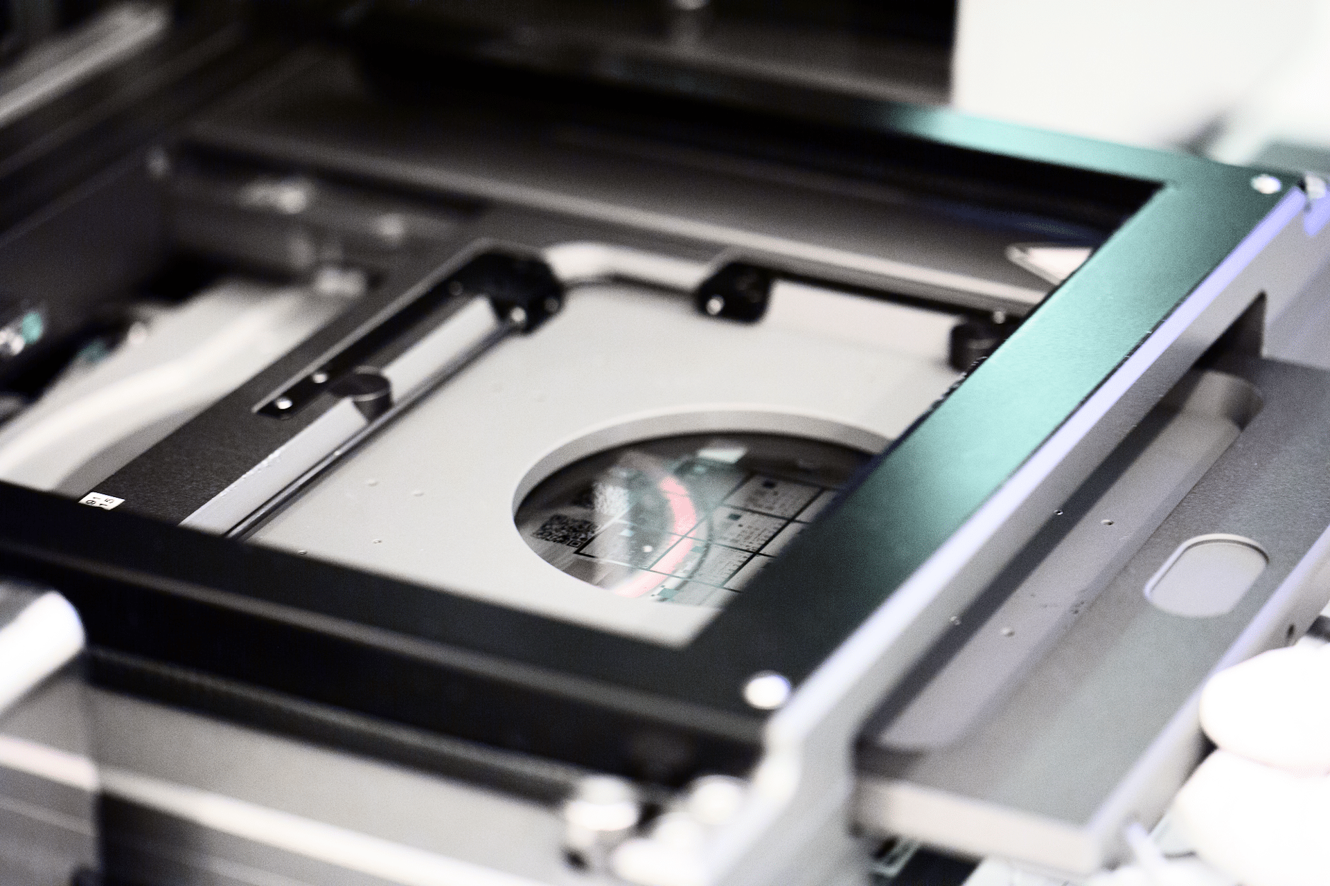 Close-up of a flatbed scanner with the lid open, showing the glass surface and part of the scanner's frame.