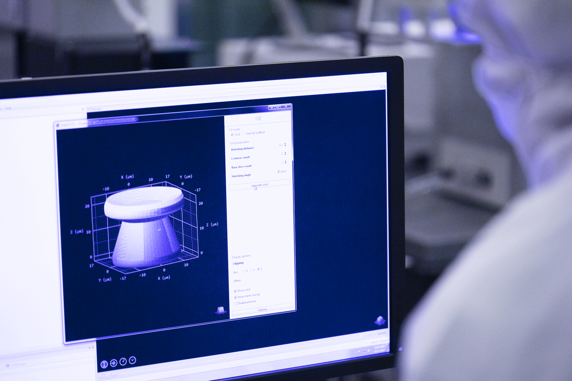 Scientist analyzing a 3D model on a computer screen in a lab environment.