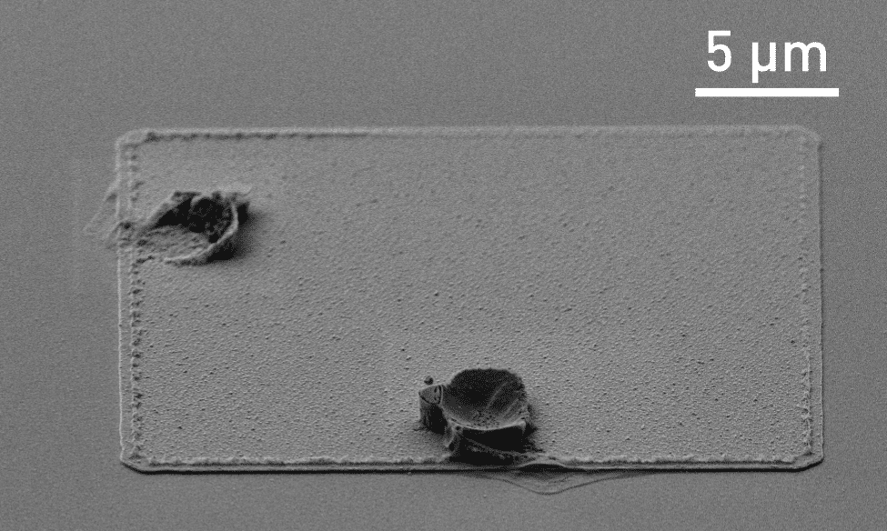 SEM image of corrosion on dry-etched aluminum features masked with HPR504 photoresist.